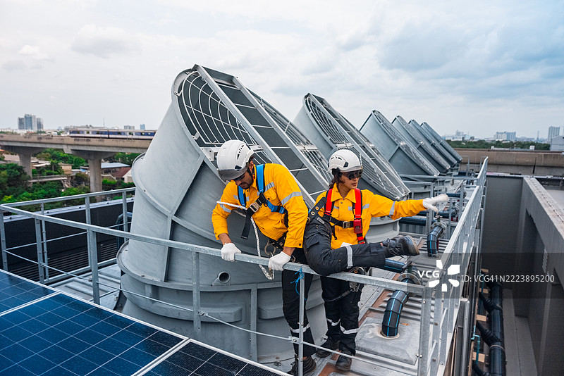一名工程师正在检查建筑工地上的屋顶太阳能电池板图片素材