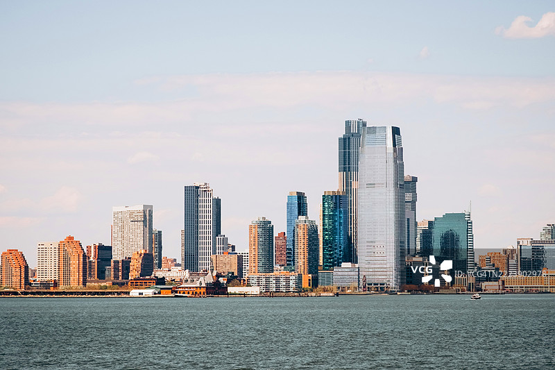 横跨哈德逊河眺望泽西城的天际线，高耸的现代建筑在柔和微阴的天空下图片素材