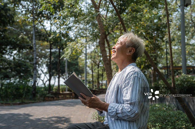 老年人在公园里安静地阅读一本书图片素材