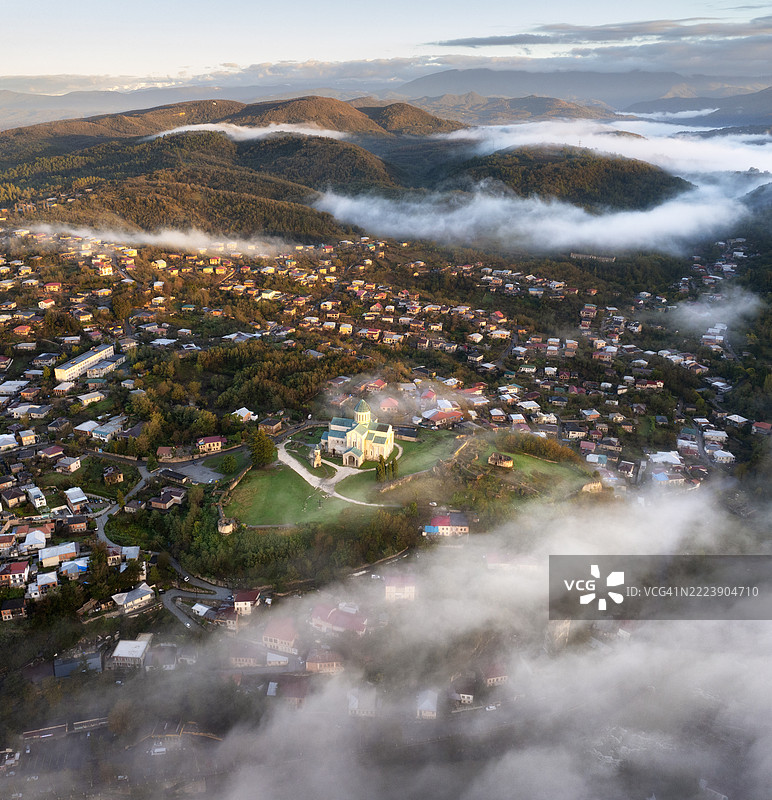 格鲁吉亚库塔伊西的巴格拉提大教堂在日出时分升起于晨雾之上。鸟瞰图。图片素材