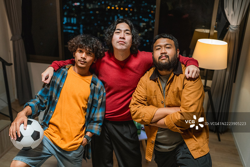 一群兴奋的足球迷在家中为比赛欢呼的肖像图片素材