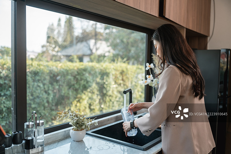 女商人在厨房清洗蛋白质摇摇杯图片素材