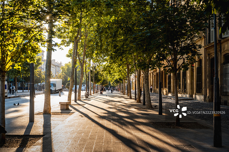 在法国普罗旺斯-阿尔卑斯-蓝色海岸的艾克斯-普罗旺斯，行人大道沐浴在温暖的阳光下图片素材