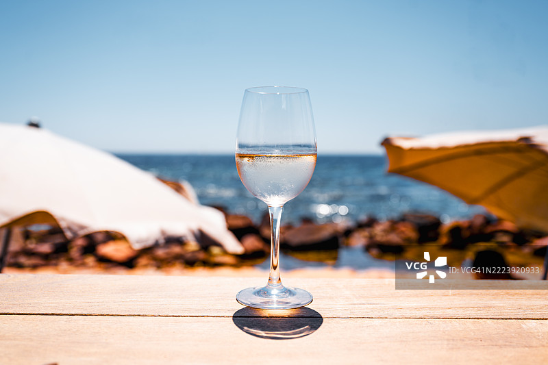海边桌子上的一杯白葡萄酒图片素材