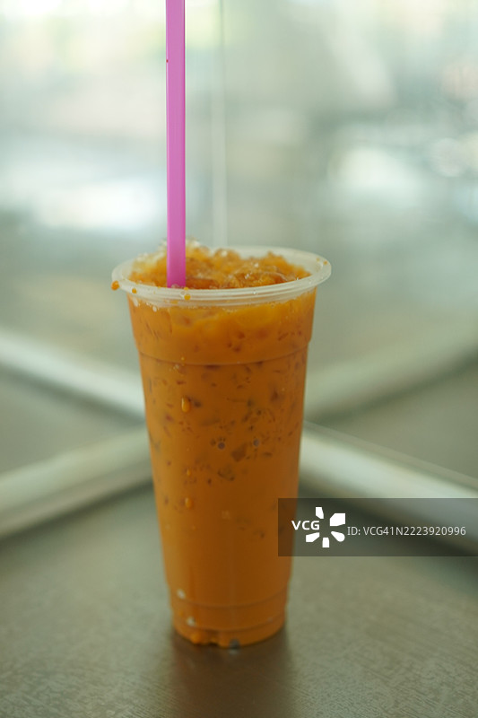 塑料杯中的冰红茶放在桌子上图片素材