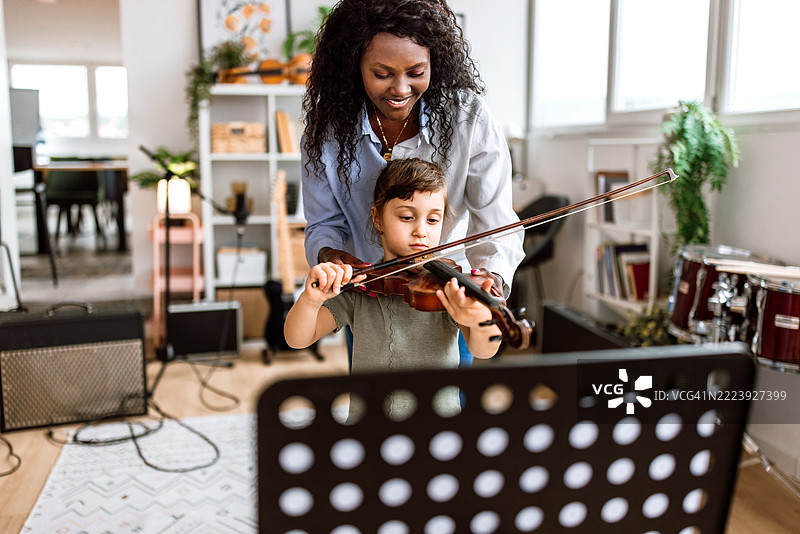 女孩在音乐学校的音乐课上拉小提琴。图片素材