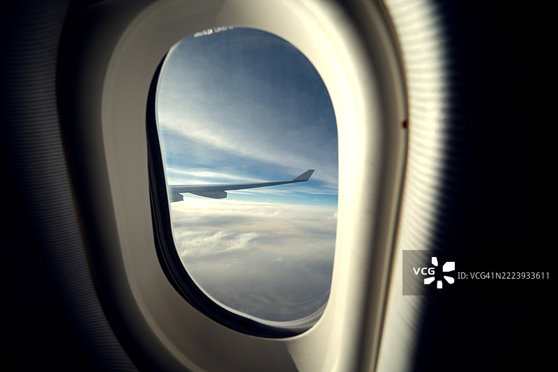 从飞机内部向外望去，飞机飞行在云层之上。图片素材