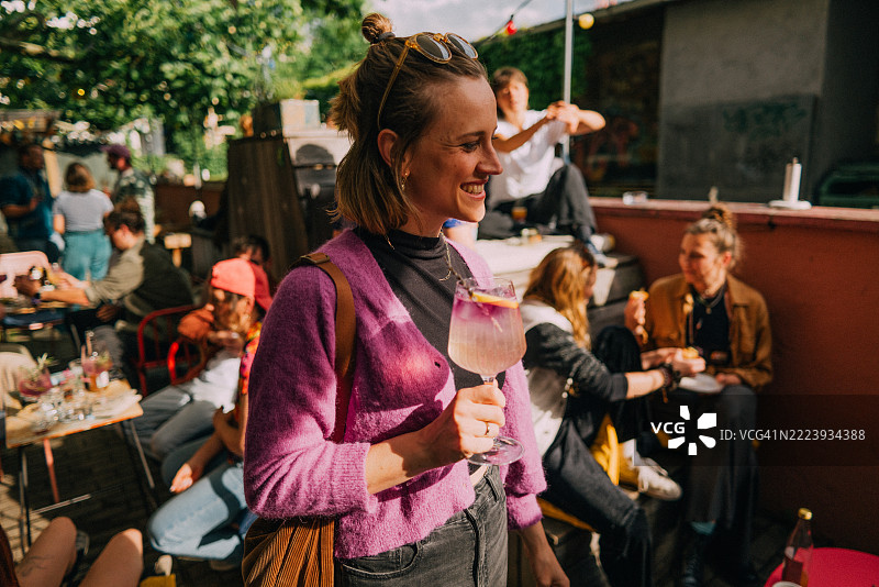年轻女性在户外与朋友们一起享受饮品，参加社交聚会图片素材