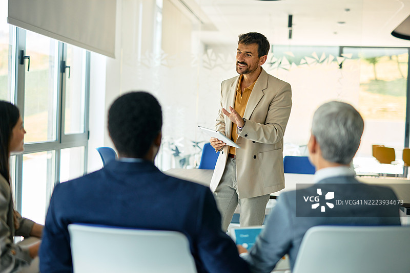 中年经理使用平板电脑主持商务会议图片素材