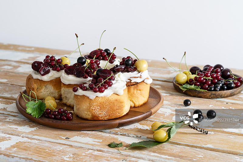 夏季肉桂卷配奶油奶酪糖霜和新鲜浆果图片素材