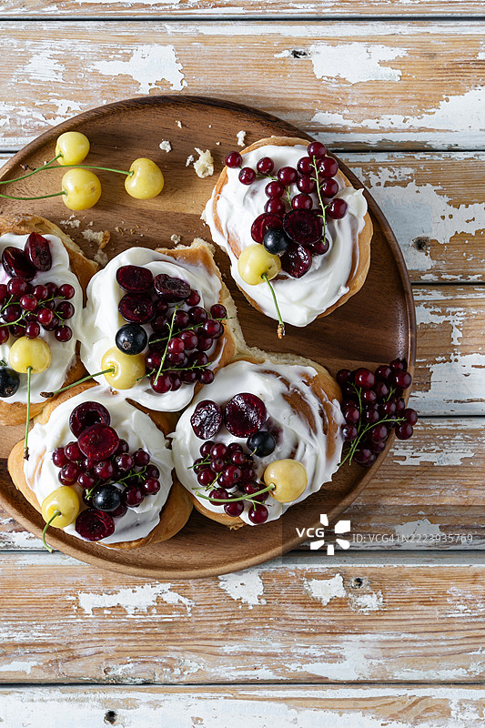 夏季肉桂卷配奶油奶酪糖霜和新鲜浆果图片素材