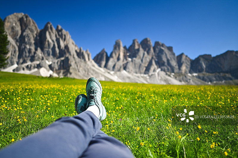 徒步旅行者在草地上放松，欣赏多洛米蒂山的美景图片素材