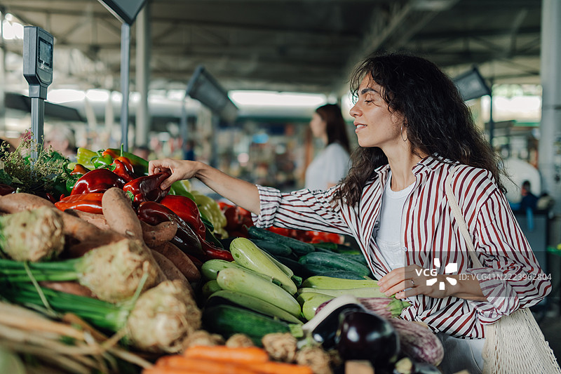 年轻女性在农贸市场挑选红椒图片素材