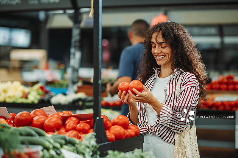 女性在农贸市场挑选西红柿图片素材
