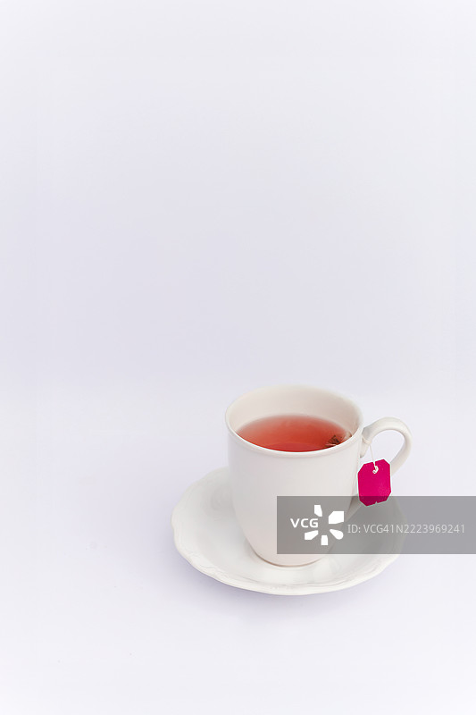 放松概念：白色背景上的热草药茶与白色杯子图片素材