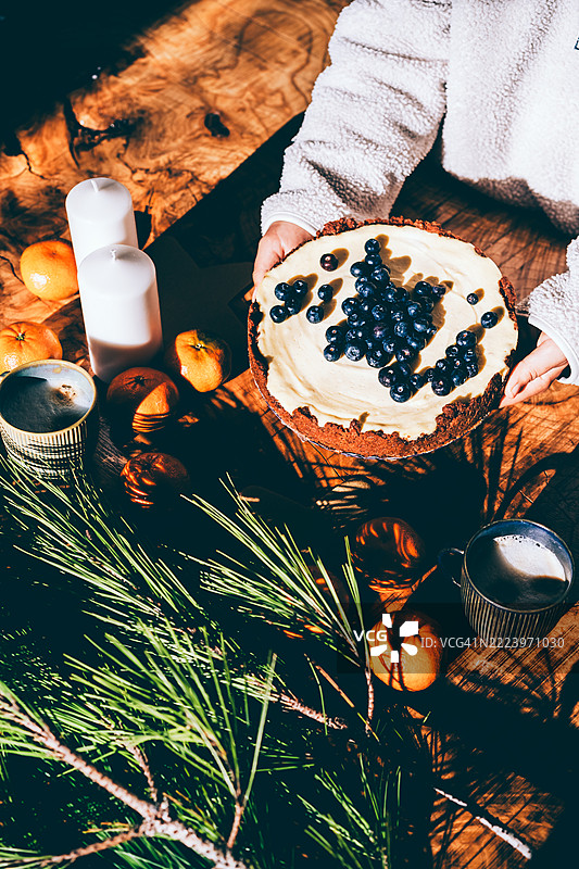 节日圣诞餐桌布置，搭配芝士蛋糕和冬季绿叶图片素材