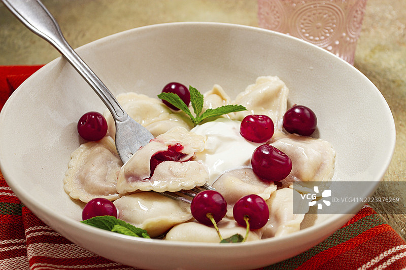 传统饺子配樱桃和酸奶，特写，无人。图片素材