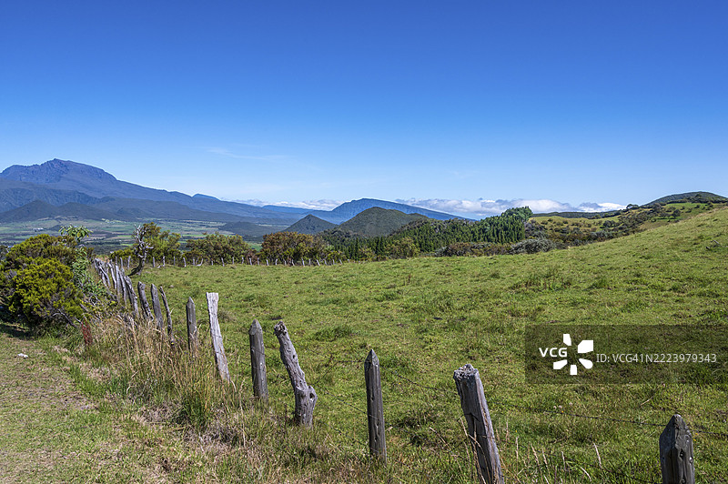 位于法属留尼旺岛974省的火山路线上的咖啡平原，绿草如茵的牧场，远处可见已 extinct 的皮通·德·尼日火山峰。图片素材