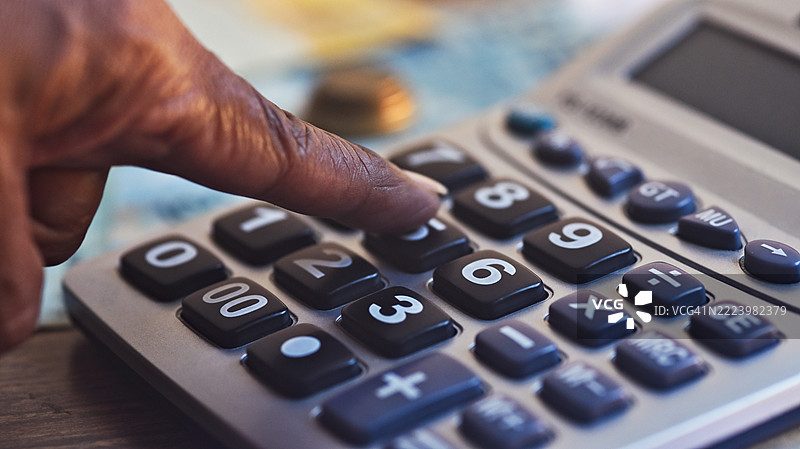 巴西货币雷亚尔纸币放在木桌上，旁边有计算器和钢笔。图片素材