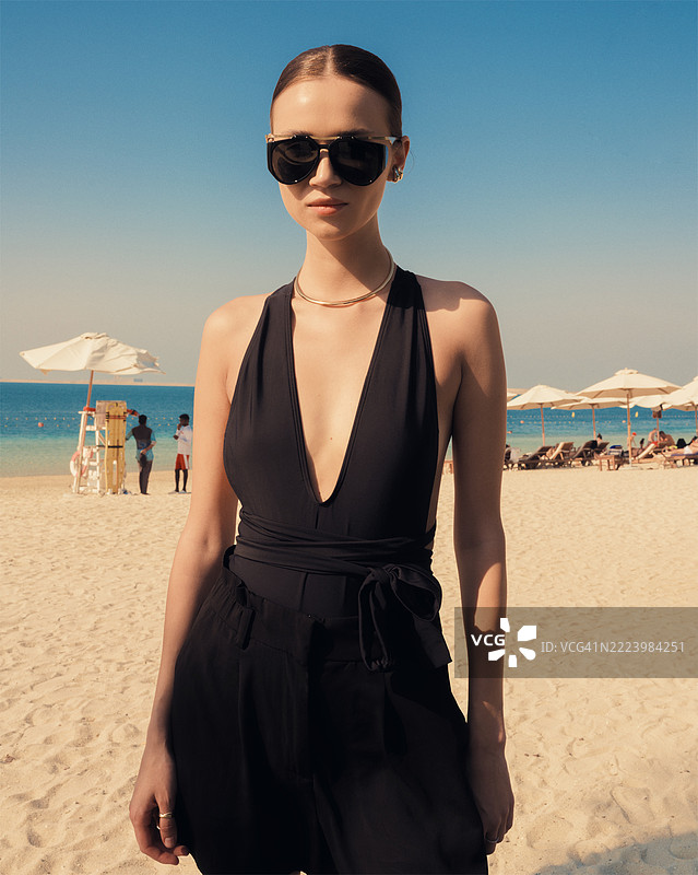 美丽的女孩在海滩上戴着太阳镜图片素材