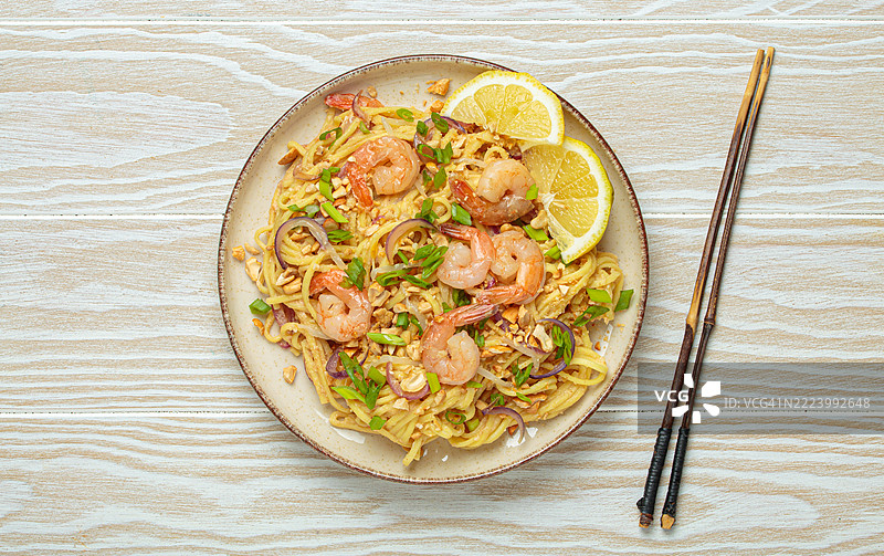 虾仁泰式炒米粉与筷子放在白色木桌上图片素材