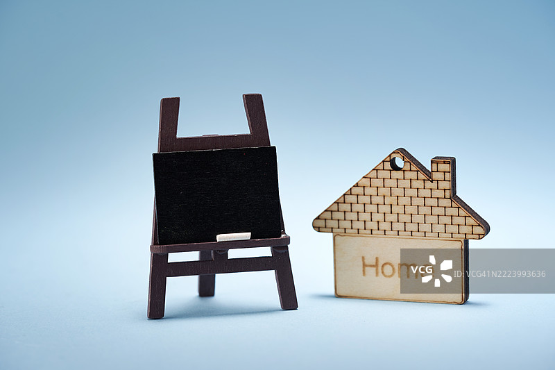 小黑板上放着微型模型房屋，背景为蓝色，马来西亚图片素材