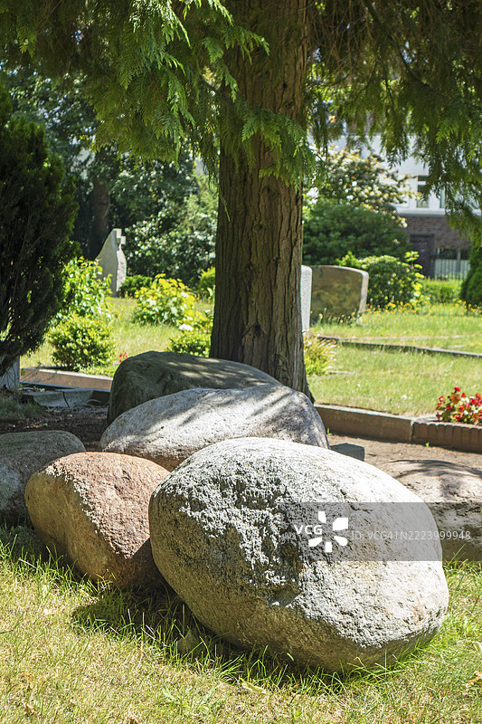巨大的不规则石块、巨石、花岗岩石头，路德教墓地，海斯费尔德街，莱尔，东弗里西亚，德国，欧洲图片素材