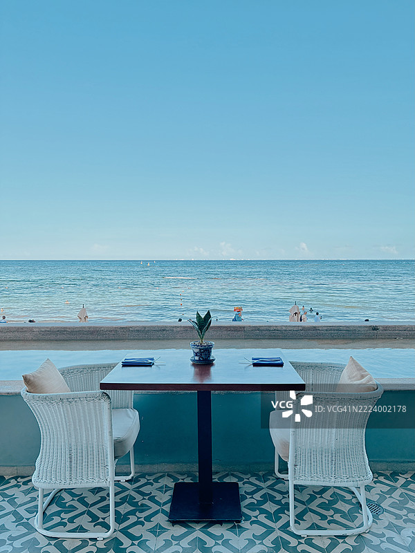 空荡荡的椅子和桌子在海滩上，背景是晴朗的天空，墨西哥卡门海滩。图片素材