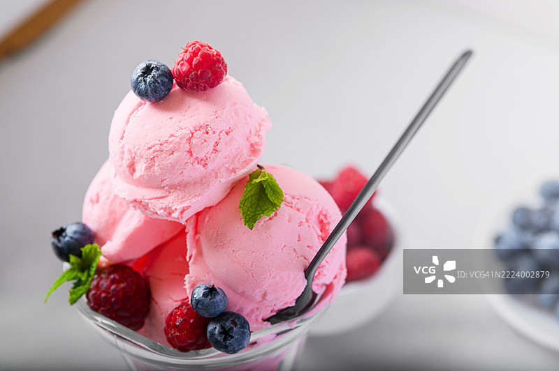 粉色冰淇淋配新鲜浆果和薄荷，盛在玻璃碗中图片素材