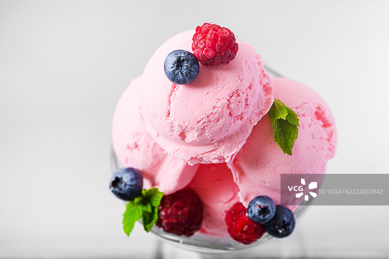 粉色冰淇淋配新鲜浆果和薄荷，盛在玻璃碗中图片素材