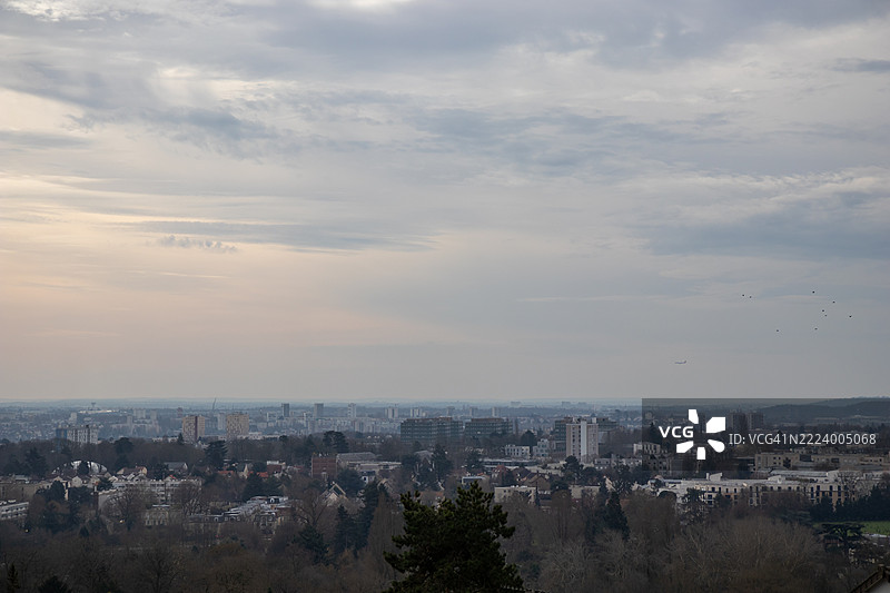 法国，巴黎，2025年2月21日 一览巴黎屋顶的全景，映衬着柔和的天空图片素材