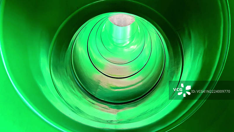 体验在灯光中扭动的绿色水滑梯的刺激感图片素材