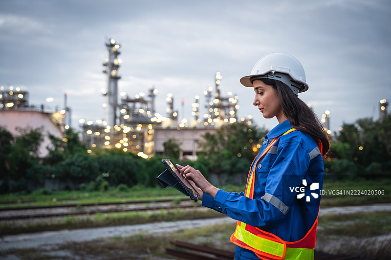 工程师在工业石油炼油厂附近监测环境条件图片素材
