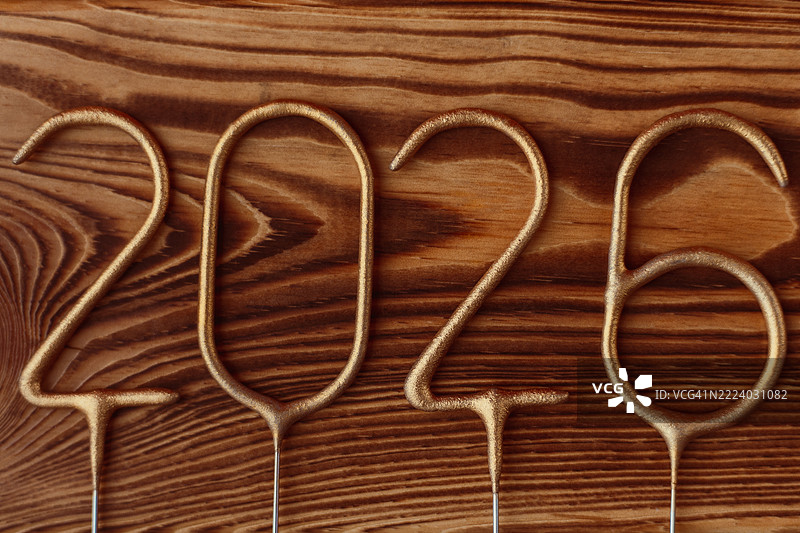 2026年金色数字放在木质表面上。图片素材