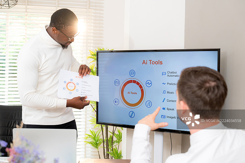 多元化工作场所的商业团队在办公室讨论人工智能工具，进行集团合作和技术营销规划，黑人男性商业领袖，数字工作流程。图片素材