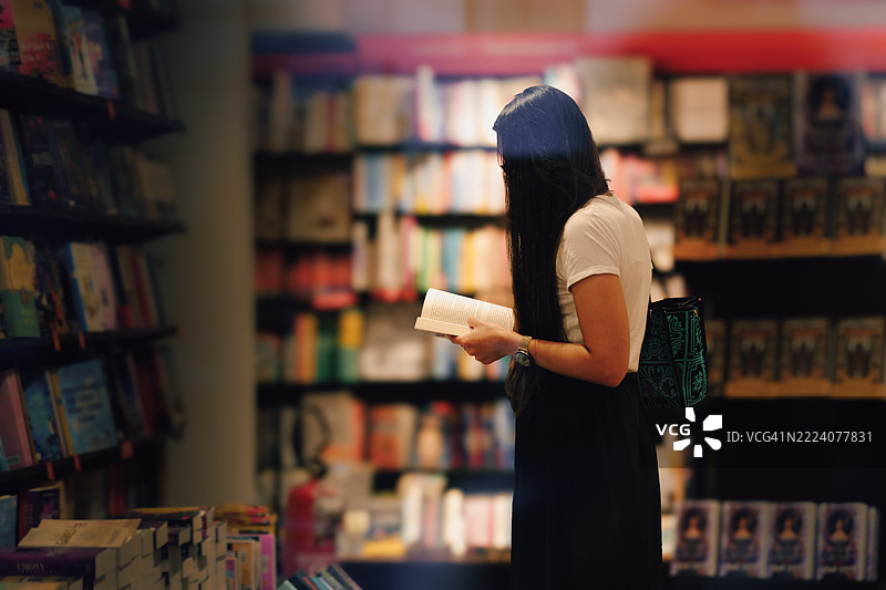 女人在书店翻阅书籍——热爱阅读与文化图片素材