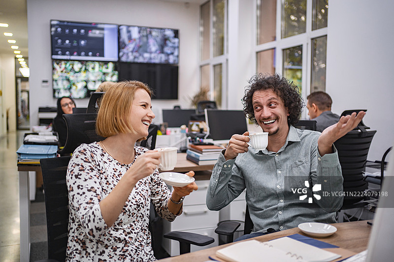 保安们在享受咖啡休息时间，欢笑着聊天。图片素材