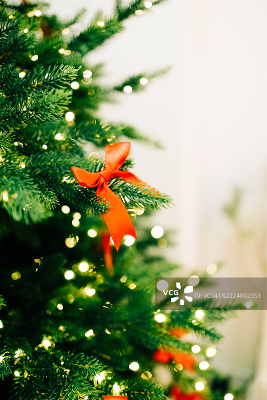 节日气氛的圣诞树，装饰着红色蝴蝶结和灯饰图片素材