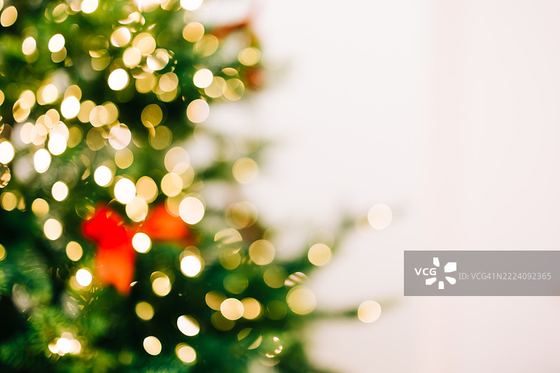 模糊的圣诞树，配有红色蝴蝶结和散景灯光图片素材