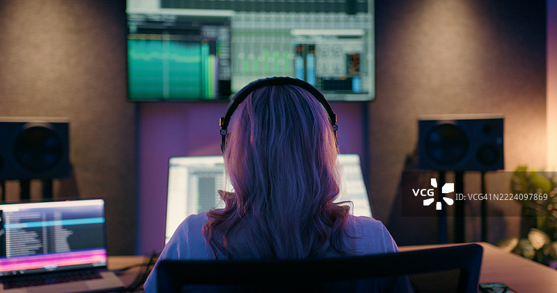 录音室，音乐设备，背影女性使用技术进行编辑、音频和声音设计。技术人员，制作人和使用调音台、控制器和混音器进行歌曲、音轨和创作的人。图片素材