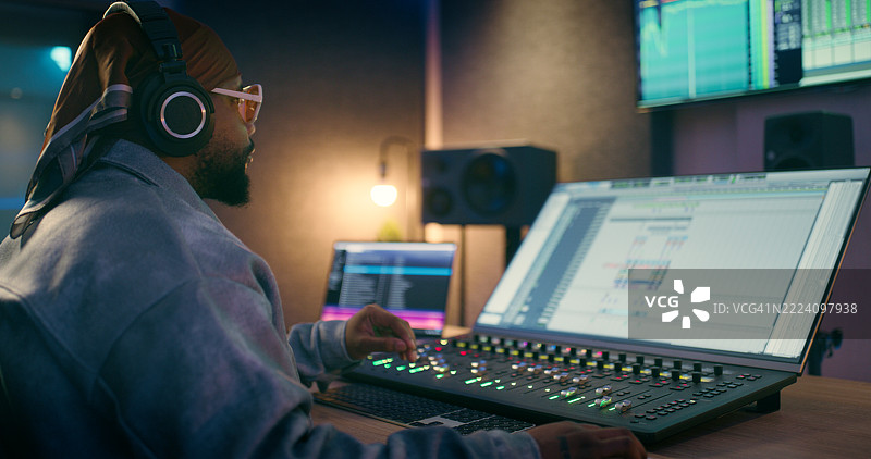 录音室，音乐制作人和带有编辑设备的男子，音频和声音设计。技术人员，制作人和带有调音台、控制器和数字混音器的人，用于歌曲、音轨和录音。图片素材