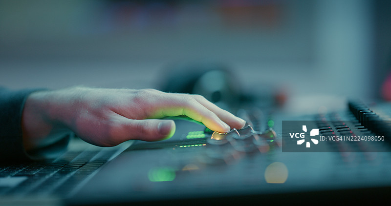 音乐、DJ和录音室中音响工程师手中的调音台，适用于歌曲编辑或制作。音频技术员、数字作曲家和均衡器设备，特写制作人和音轨。图片素材