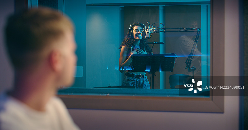 录音室，音乐家和女性制作人一起录唱歌曲、音轨和专辑音频。创意、音乐行业和艺术家在技术人员的陪伴下进行表演、声音和排练。图片素材