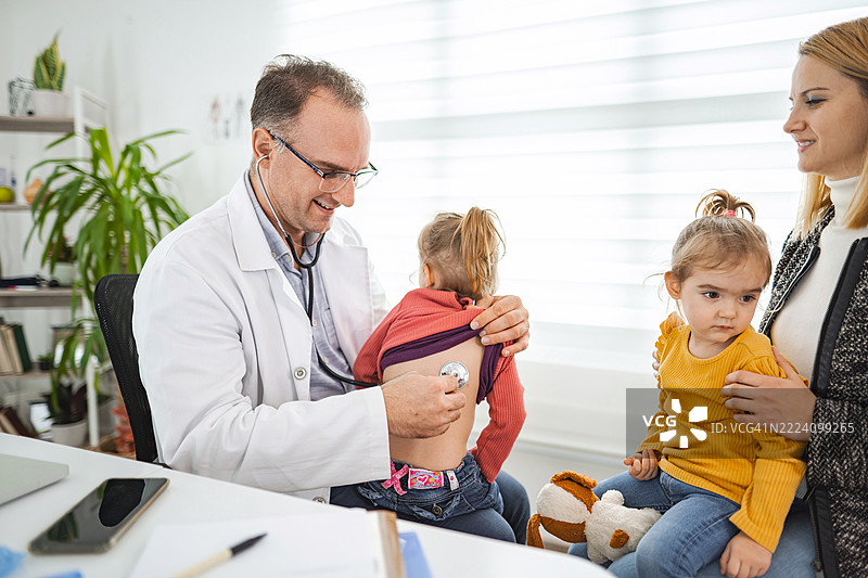 儿科医生在医疗咨询中用听诊器检查小女孩图片素材