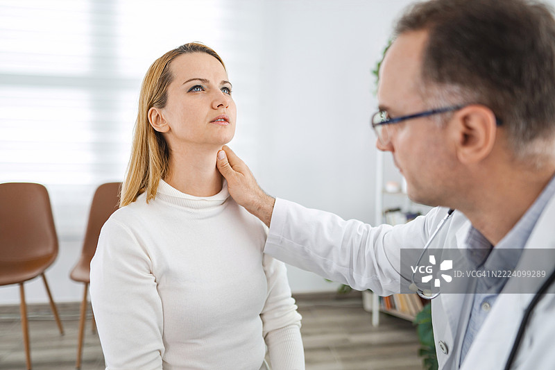 医生在医疗办公室检查病人的颈部图片素材