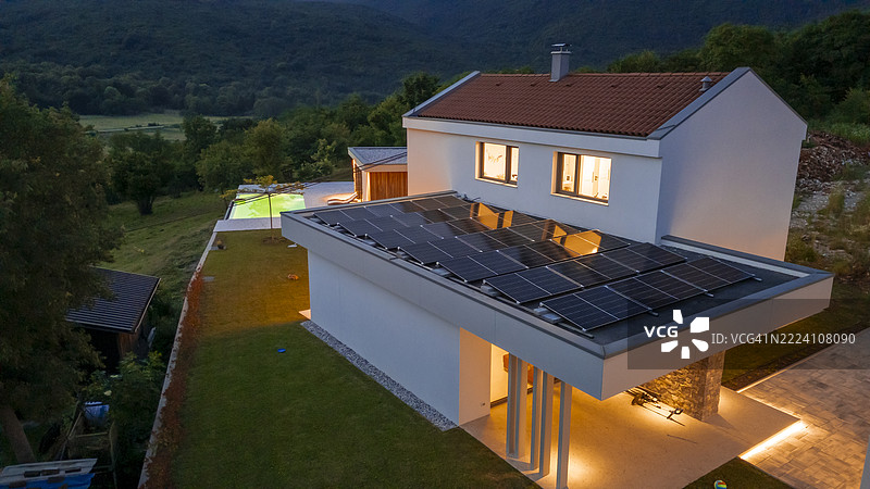 现代可持续住宅，蓝色时刻的乡村宁静中装有太阳能板图片素材