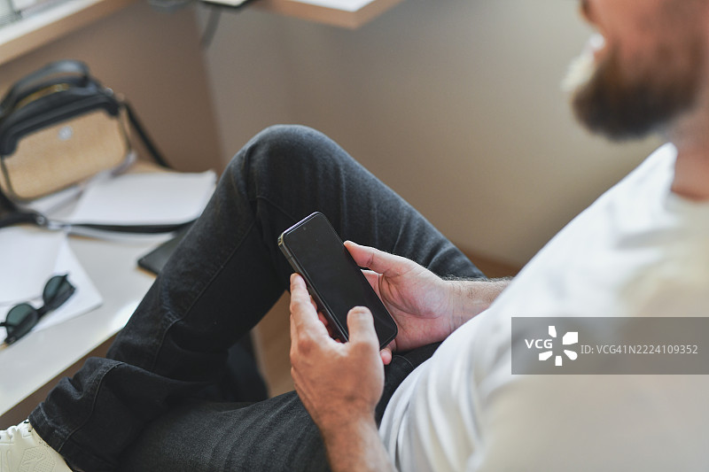 分心的男性员工在智能手机上查看社交媒体，逃避工作任务图片素材