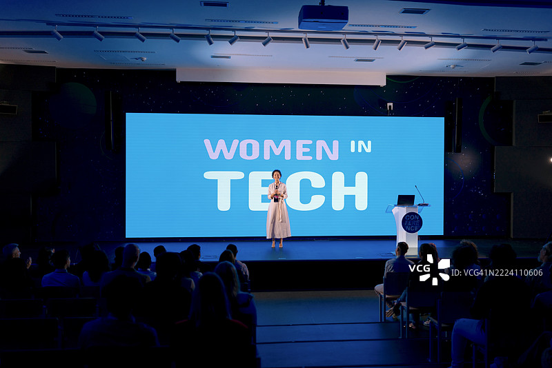 自信的演讲者在现代场馆的女性科技会议上发言图片素材