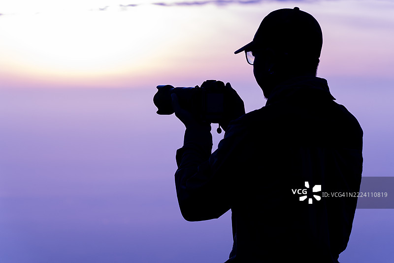 日出时分，摄影师的剪影在户外冒险自然旅行生活中拍摄，激发灵感。图片素材