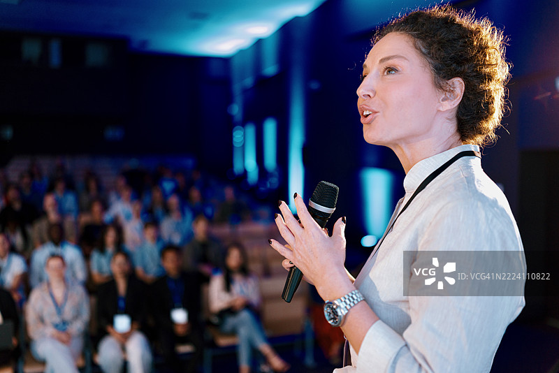 自信的演讲者在现代会议活动上介绍女性在科技领域的表现图片素材